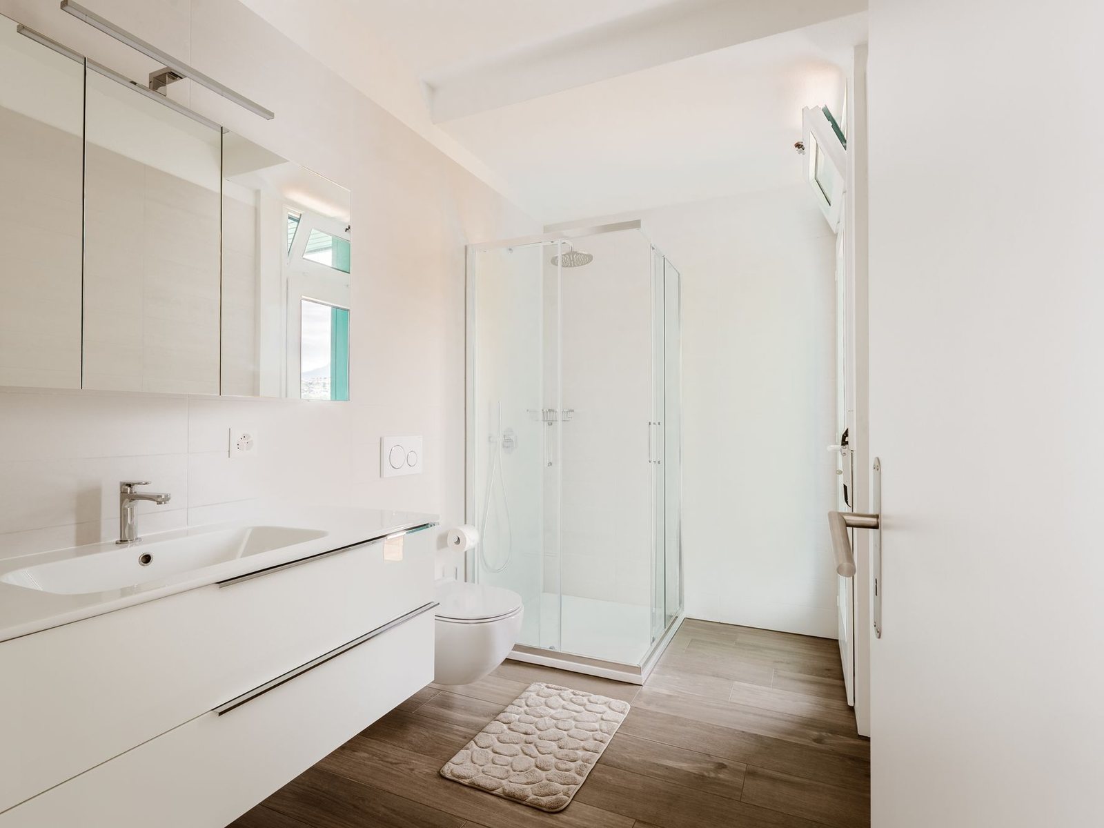 Helles Bad mit Duschkabine, Wand-WC und Waschtisch